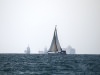 Парусник в Хайфском заливе на фоне грузовых кораблей в Средиземном море