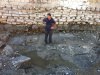 Работник археологической группы стоит на древнем причале в Акко